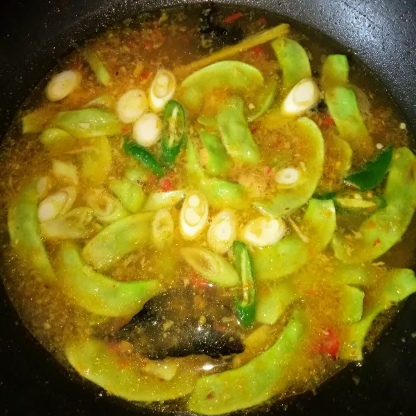 Masukkan cabe hijau dan daun bawang, tambahkan air, setelah mendidih masukkan koro.
