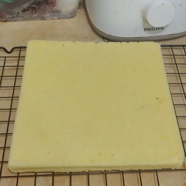 Dingingkan bolu di atas cooling rack dan belah menjadi 2 bagian sama rata.