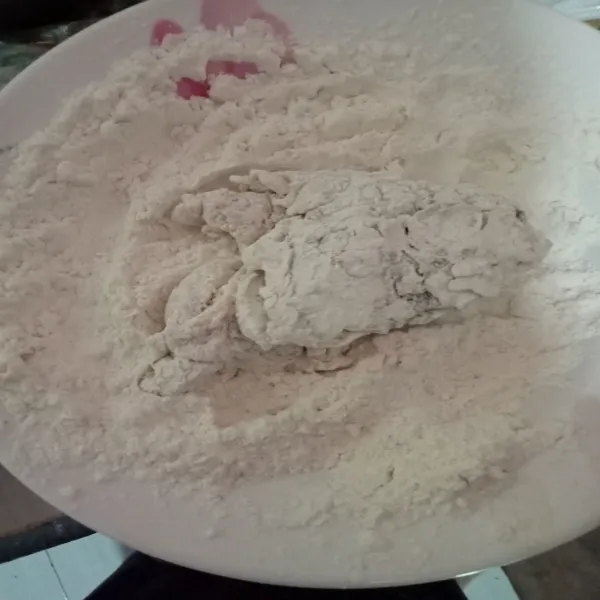 Ambil 1 potong ayam, lalu baluri tepung, tekan tekan agar tepung menempel.