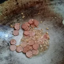 Panaskan 2 sdm minyak goreng. Tumis bawang putih sampai harum. Kemudian masukkan sosis, tumis sampai sosis berubah warna.