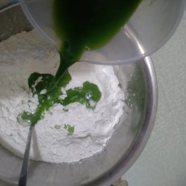 Kemudian tuangkan jus pandan pada campuran tepung.