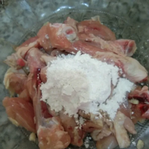 Beri tepung terigu, aduk rata supaya tepung menempel pada ayam.