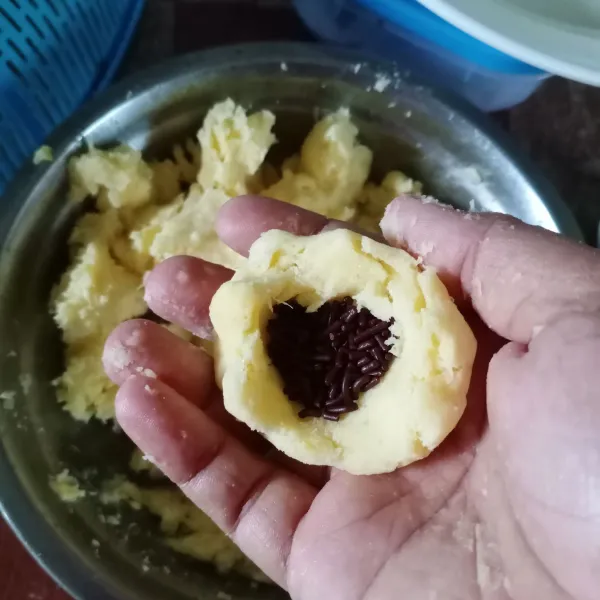 Ambil sedikit adonan singkong, isi dengan meses coklat. Kemudian bentuk bulat pipih.