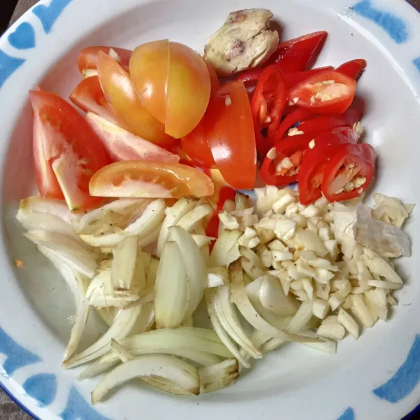 Potong-potong cabai, tomat, dan bawang bombai. Geprek dan cincang bawang putih.