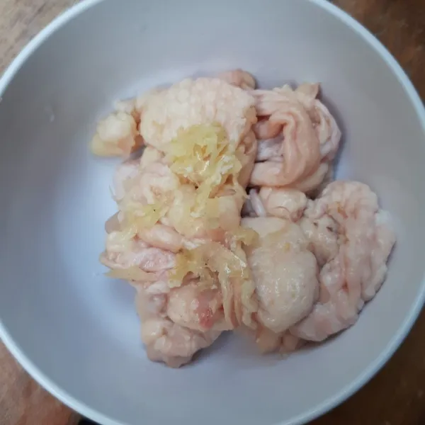 Cuci bersih kulit ayam kemudian lumuri dengan bawang putih cincang.