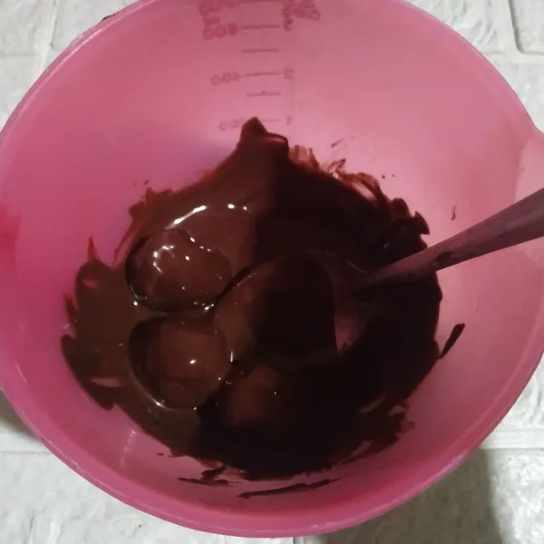 Masukkan ke dalam wadah yang berisikan lelehan coklat. Lumuri adonan dengan coklat leleh hingga terlapisi seluruh bagian adonan.