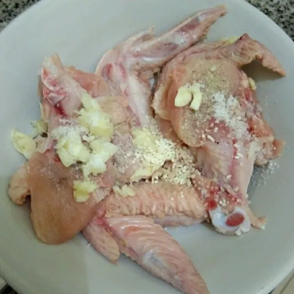 Lumuri ayam dengan garam, kaldu jamur, merica bubuk dan bawang putih, aduk rata dan diamkan minimal 30 menit.