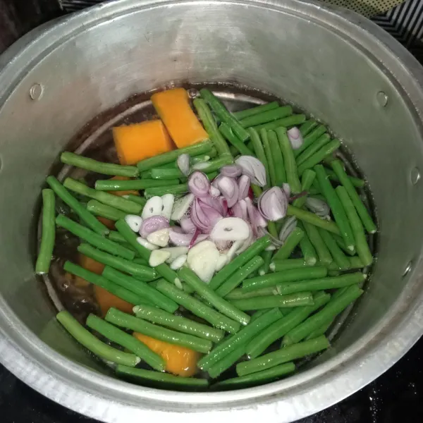 Masukkan kacang panjang, bawang merah dan bawang putih. Masak hingga kacang panjang layu.