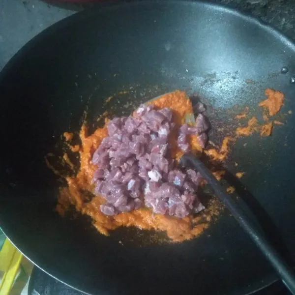 Masukkan daging, aduk-aduk hingga rata dengan bumbu.