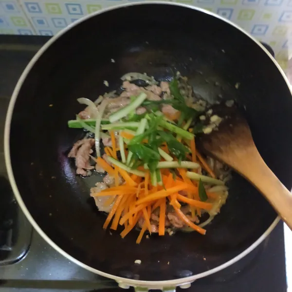 Masukkan wortel, timun, dan daun bawang. Masak hingga layu.