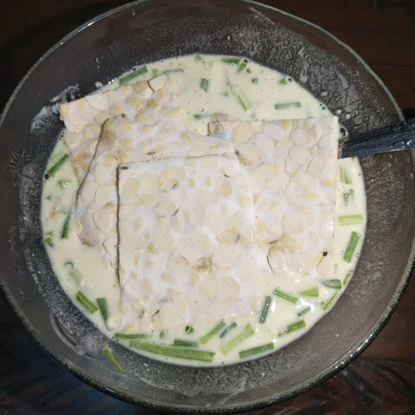 Kemudian celupkan tempe ke dalam adonan tepung.