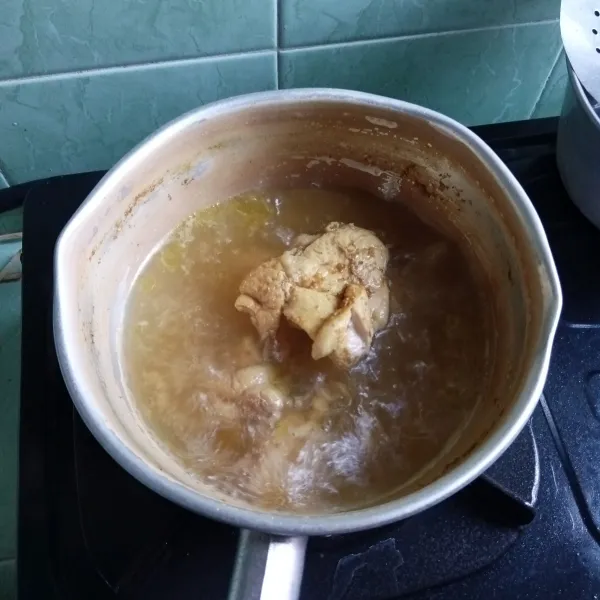 Rebus ayam bersama bumbu ayam goreng sampai empuk.
