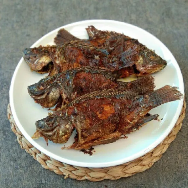 Salin ikan nila goreng creamy pada piring saji.