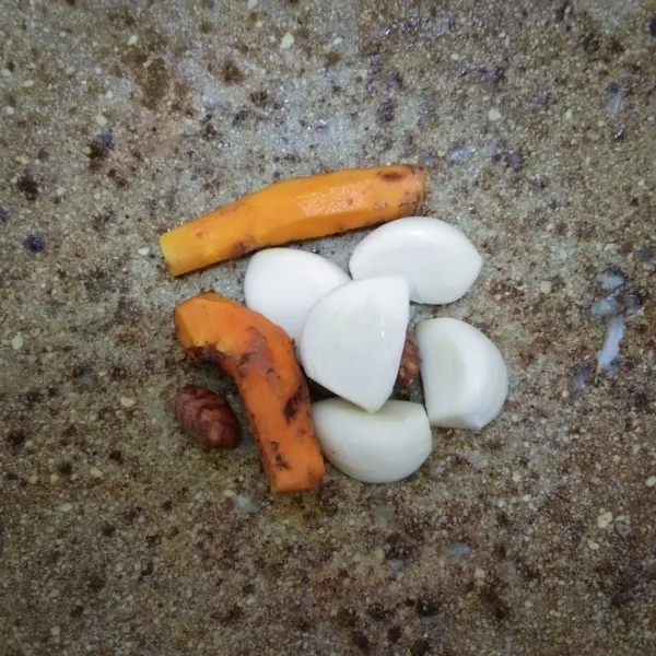 Haluskan bawang putih dan kunyit.