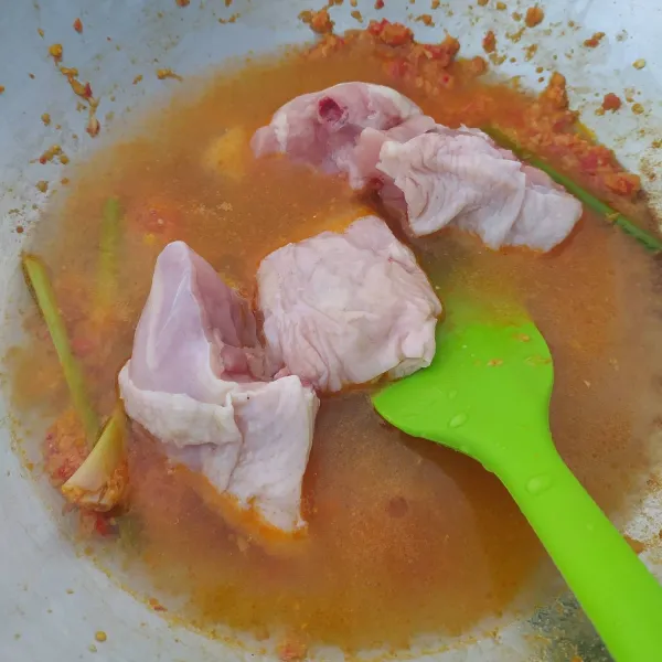 Tambahkan air dan ayam, aduk rata. Masak sampai mendidih.