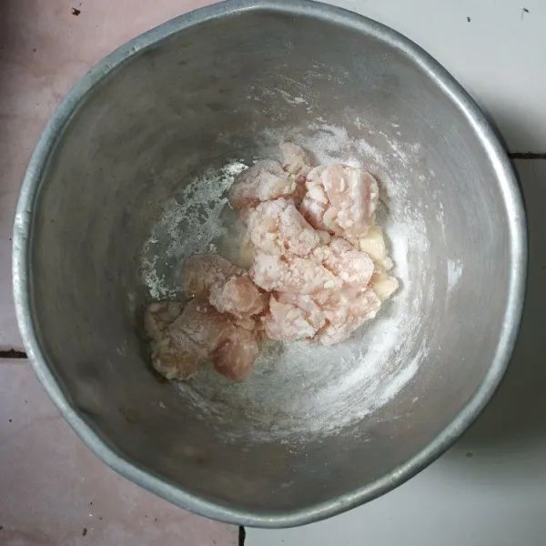 Potong fillet ayam seukuran gigitan. Beri garam dan tepung maizena, aduk hingga tepung rata dan diamkan sebentar.
