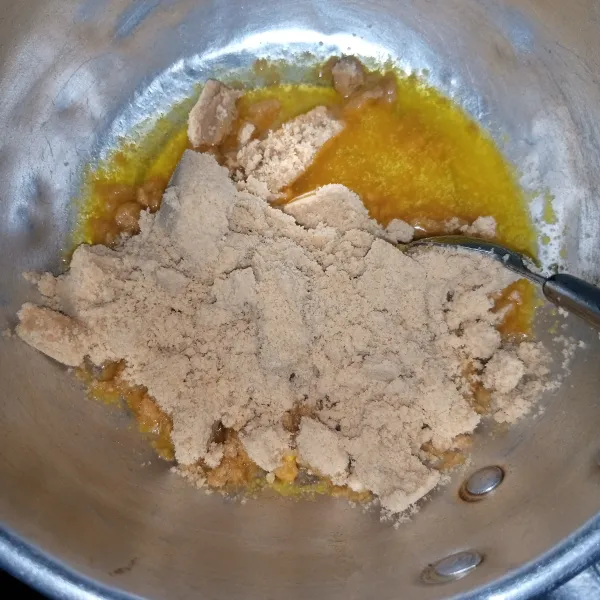 Masukkan biskuit yang sudah diblender halus kedalam margarin leleh. Aduk rata.