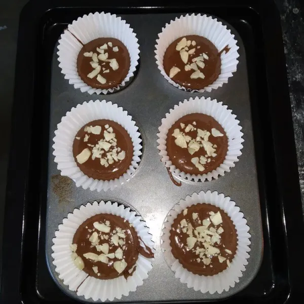 Masukkan kecdalam cetakan muffin, beri topping irisan kacang almond.