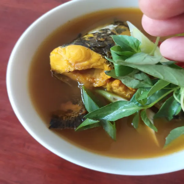 Jika rasa sudah pas, sesaat sebelum dihidangkan tambahkan daun bawang dan daun kemangi.