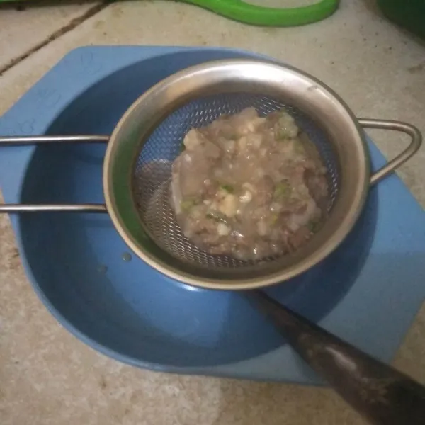 Lumatkan bubur menggunakan saringan hingga menjadi tekstur yang lembut.