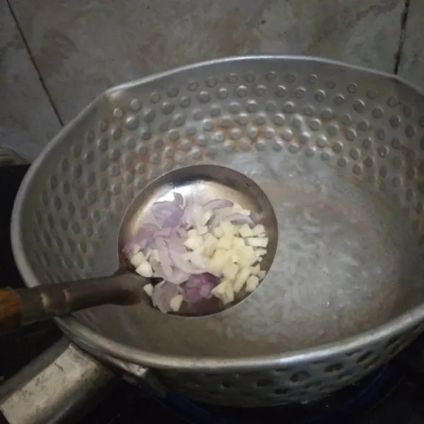 Masukkan irisan bawang merah dan bawang putih. Masak hingga nasi berubah lembek.