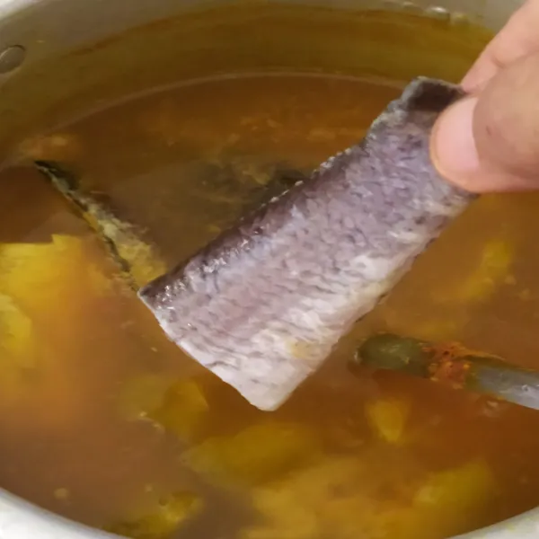 Tambahkan ikan dan belimbing wuluh. Masak menggunakan api sedang hingga ikan matang.