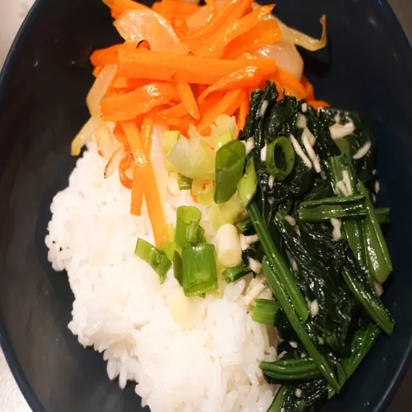 Masukkan nasi putih, tumisan wortel, bayam, dan daun bawang.