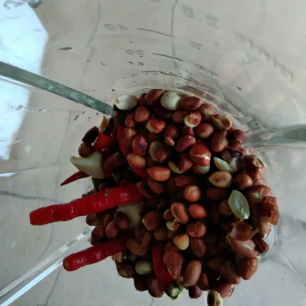 Haluskan kacang tanah sangrai, cabe merah keriring, cabe rawit dan bawang putih, beri sedikit air haluskan dengan bantuan blender.
