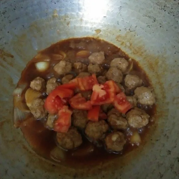 Masukkan irisan tomat, aduk.