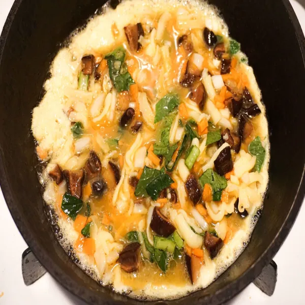 Tuang telur ke dalam wajan yang berisi minyak yang telah panas, dan tambahkan keju, masak sampai matang.