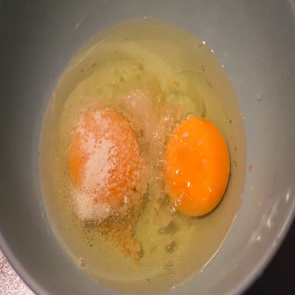 Masukkan telur ke dalam mangkuk, tambahkan bumbu, dan aduk rata.