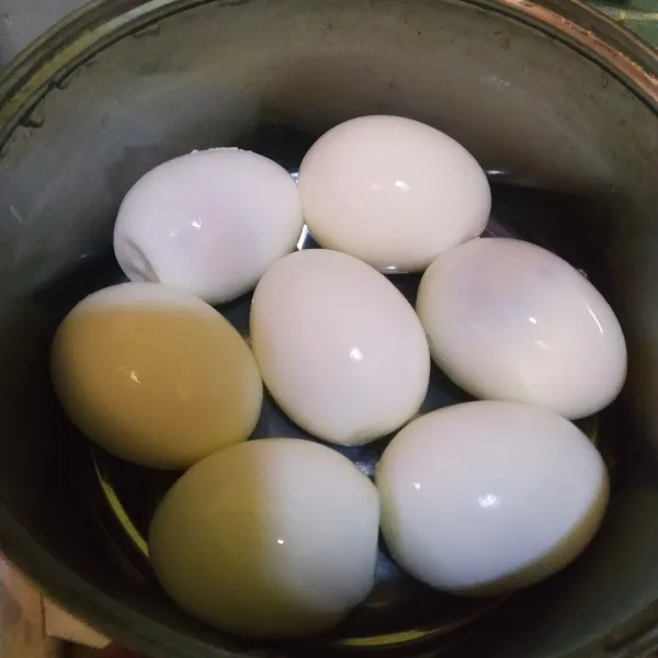 Rebus telur hingga matang, lalu kupas hingga bersih kemudian goreng sebentar.