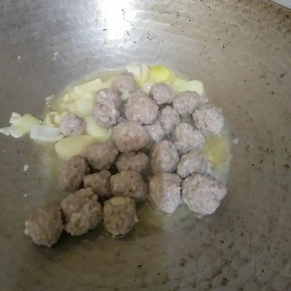 Panaskan minyak secukupnya. Tumis bawang putih dan bawang bombay hingga harum, masukkan bola-bola daging, aduk rata.