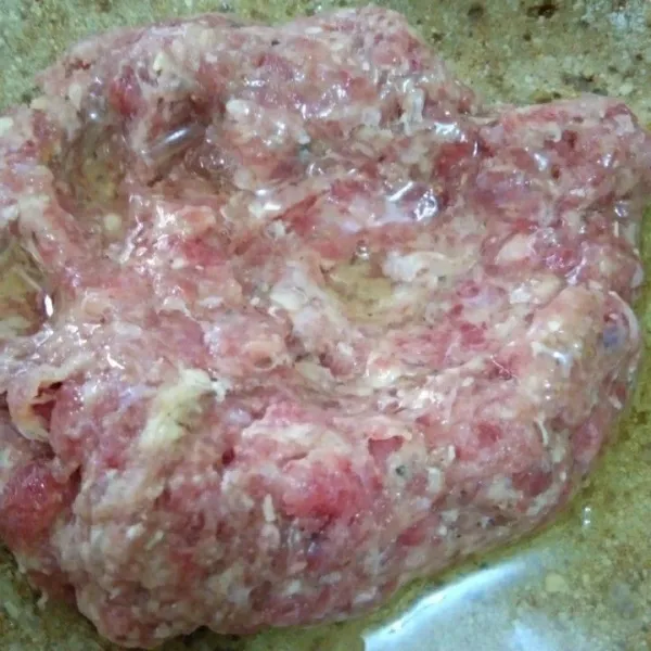 Tambahkan putih telur, aduk rata adonan daging kemudian sisihkan.
