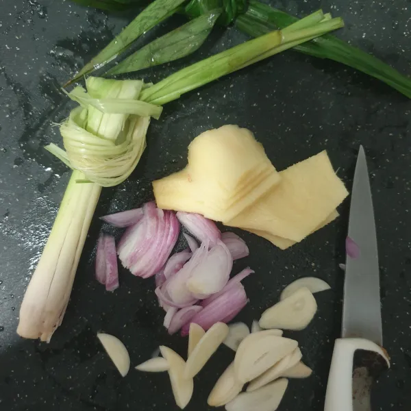Siapkan bumbu terlebih dahulu. Iris tipis bawang merah, bawang putih, jahe, simpulkan daun pandan, dan geprek serai.