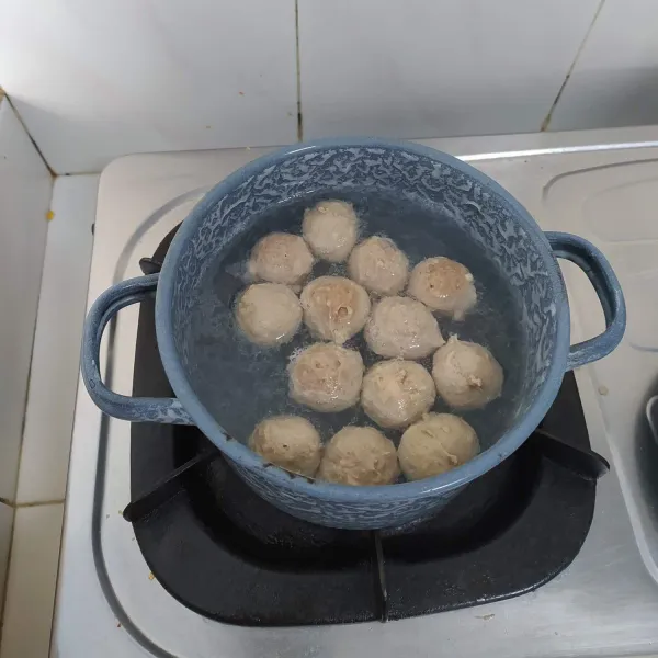 Setelah daging halus dan bumbu telah tercampur rata, rebus air hingga mendidih, kecilkan api. Cetak bulat adonan, rebus hingga matang. Tiriskan dan sisihkan. Air sisa rebusan jangan dibuang.