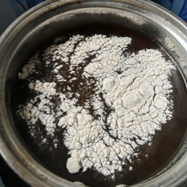 Tuang kembali air gula merah pada panci, tambahkan bubuk agar-agar, aduk hingga larut kemudian nyalakan kompor.