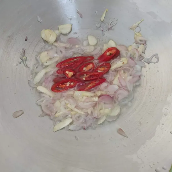 Tumis bawang merah dan bawang putih hingga harum, tambahkan irisan cabe merah besar. Tumis hingga layu.