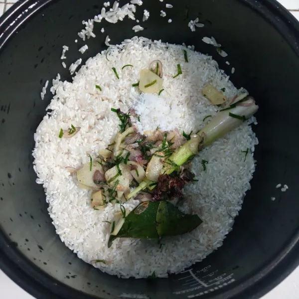 Setelah tumisan harum, masukkan bumbu ke dalam magic com yang berisi beras. Tambahkan garam, lada bubuk, dan air. Aduk rata.