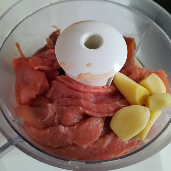 Membuat bakso: masukkan daging sapi dan bawang putih dalam chopper/food processor. Proses hingga daging 1/2 halus.
