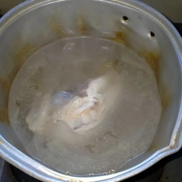 Rebus daging ayam. Jika sudah mendidih, buang buih di atasnya. Matikan kompor.