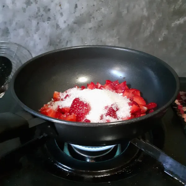 Masukkan potongan strawberry dan gula pasir ke dalam panci. Masak dengan api kecil sampai larut.