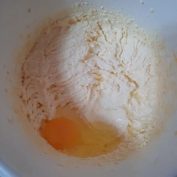 Masukkan telur satu per satu sambil dimixer hingga rata.