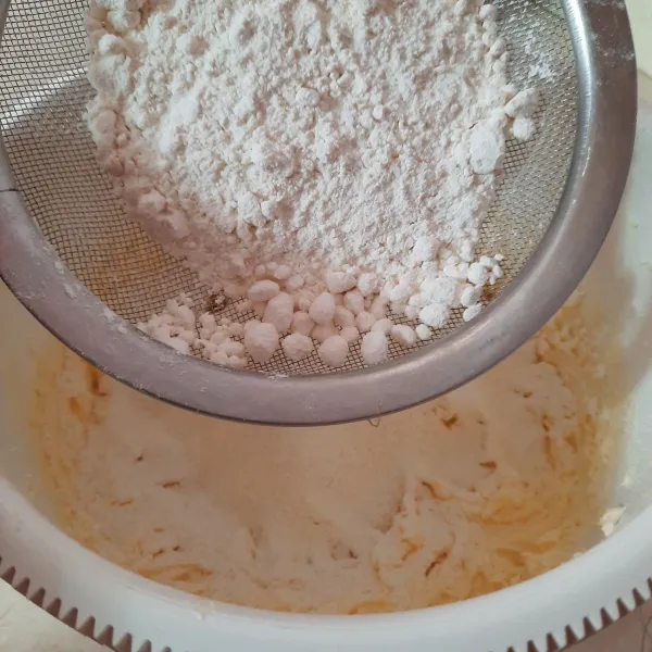 Masukkan tepung dan baking powder sambil diayak agar tidak ada yang menggumpal.