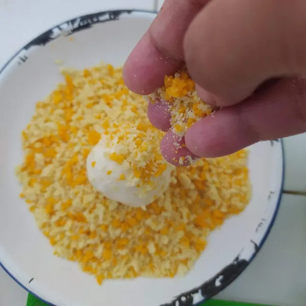 Balur bola kentang yang sudah dilapisi tepung dengan tepung roti sampai rata. Lakukan hingga habis.