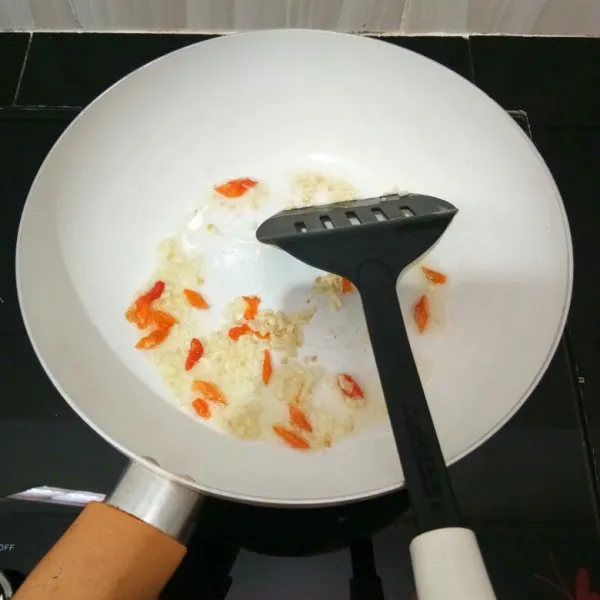 Panaskan minyak sayur. Tumis bawang putih dan cabe hingga harum.