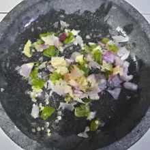Siapkan cobek. Masukkan bawang putih, bawang merah dan cabai rawit hijau. Ulek kasar.