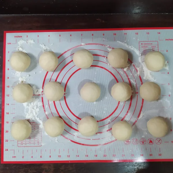 Kempiskan adonan yang telah mengembang, lalu bagi menjadi 15 bagian. Bulat-bulatkan.