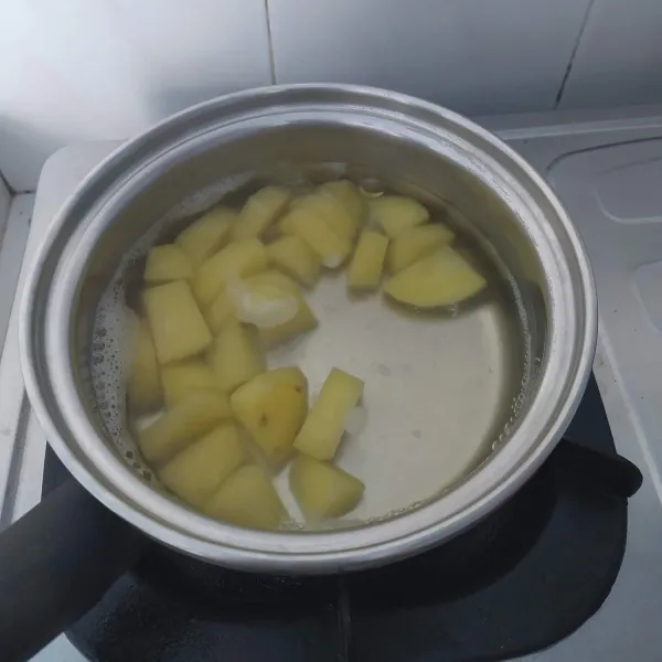 Kupas kulit kentang, kemudian rebus kentang sampai empuk, haluskan.