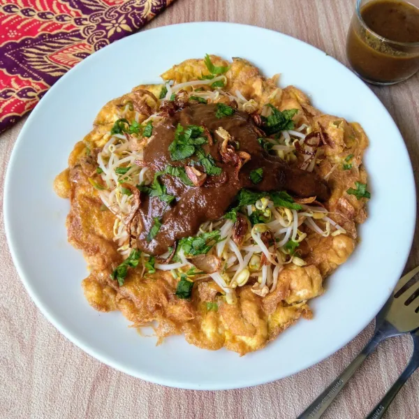 Sajikan tahu telur dengan saus kacang, irisan seledri dan bawang goreng.